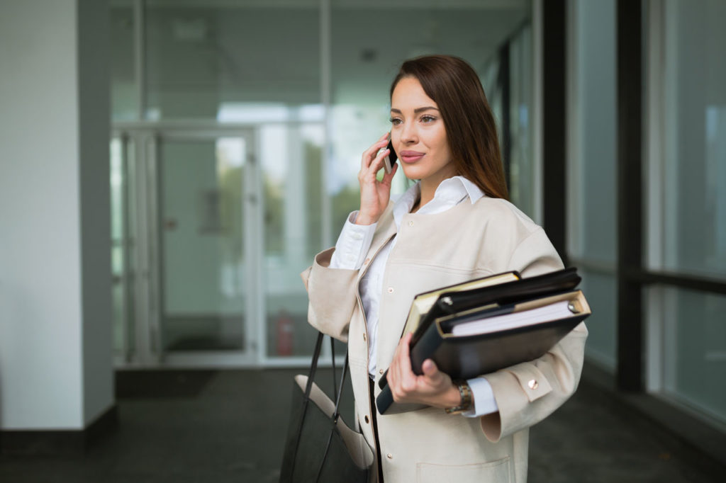 imagem-mulher-falando-ao-telefone-segundando-documentos